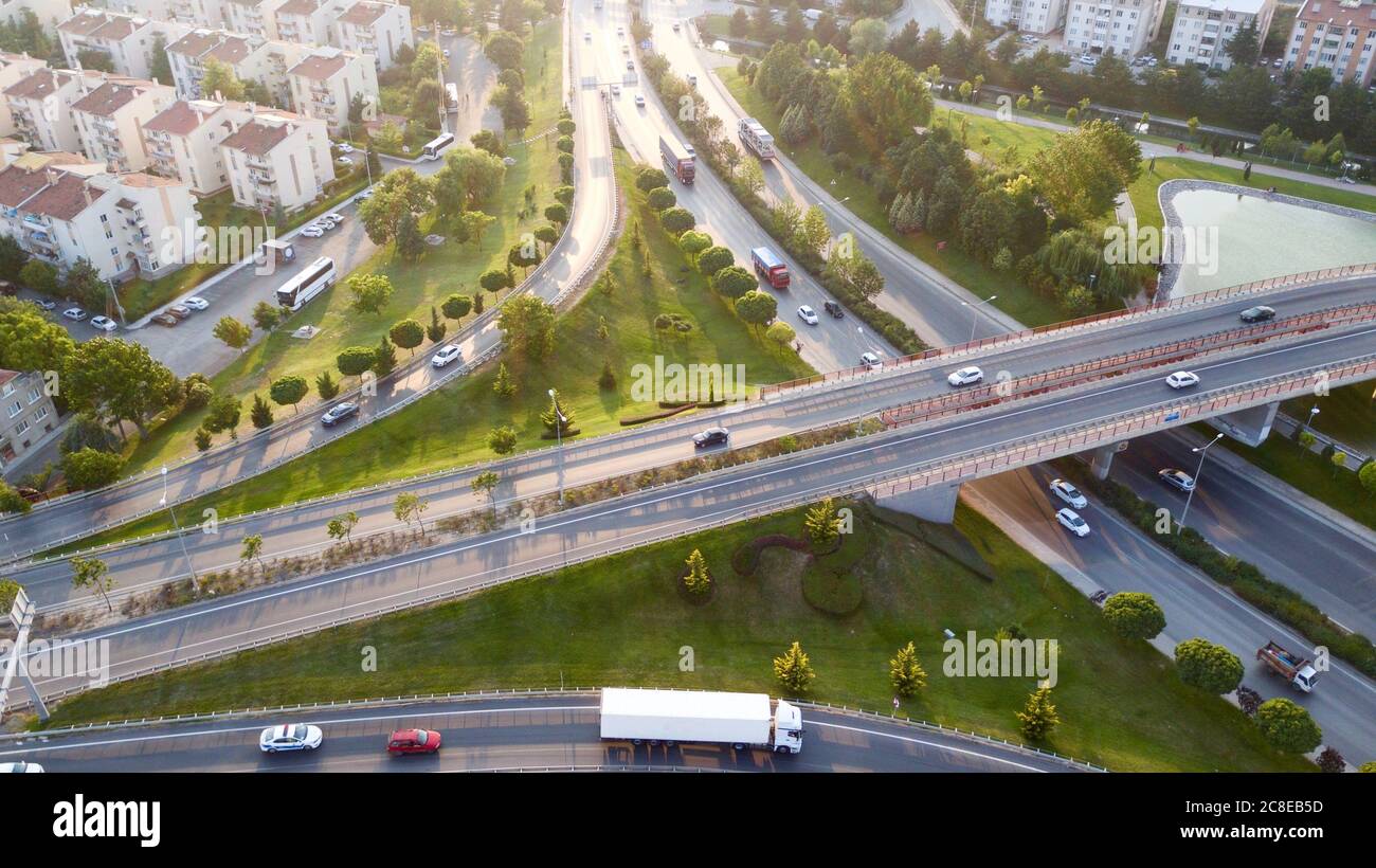 Aerial view of the roundabout on the river. Trees, overpass, buildings and vehicles can be seen. Stock Photo