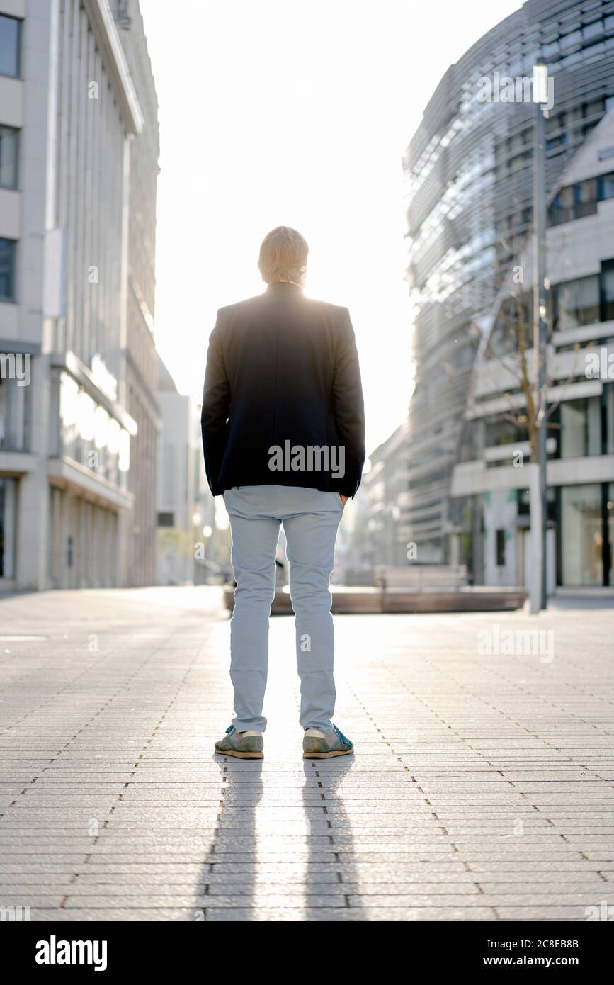 Businessman standing in the city at sunset Stock Photo