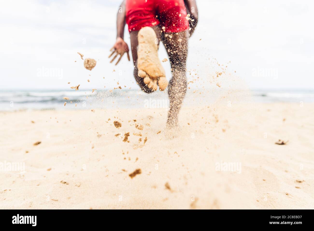 Athletic man running on beach Stock Photo