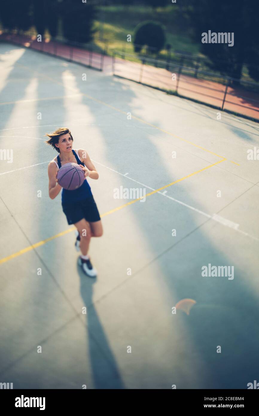 Teenage player taking shot at basketball court Stock Photo