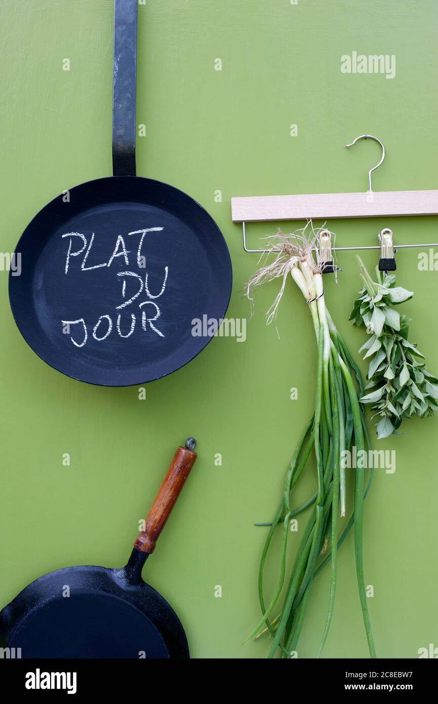 Frying pans and coathanger with herbs Stock Photo