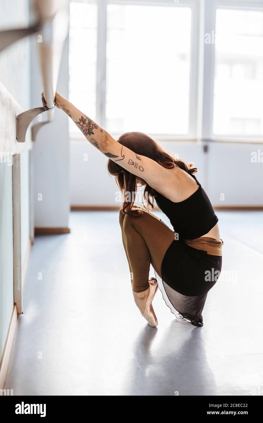 Ballerina doing stretching exercises in studio Stock Photo
