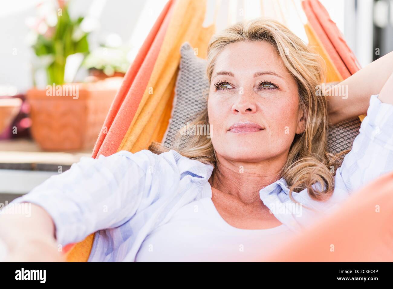 Portrait of pensive mature woman relaxing in hammock Stock Photo