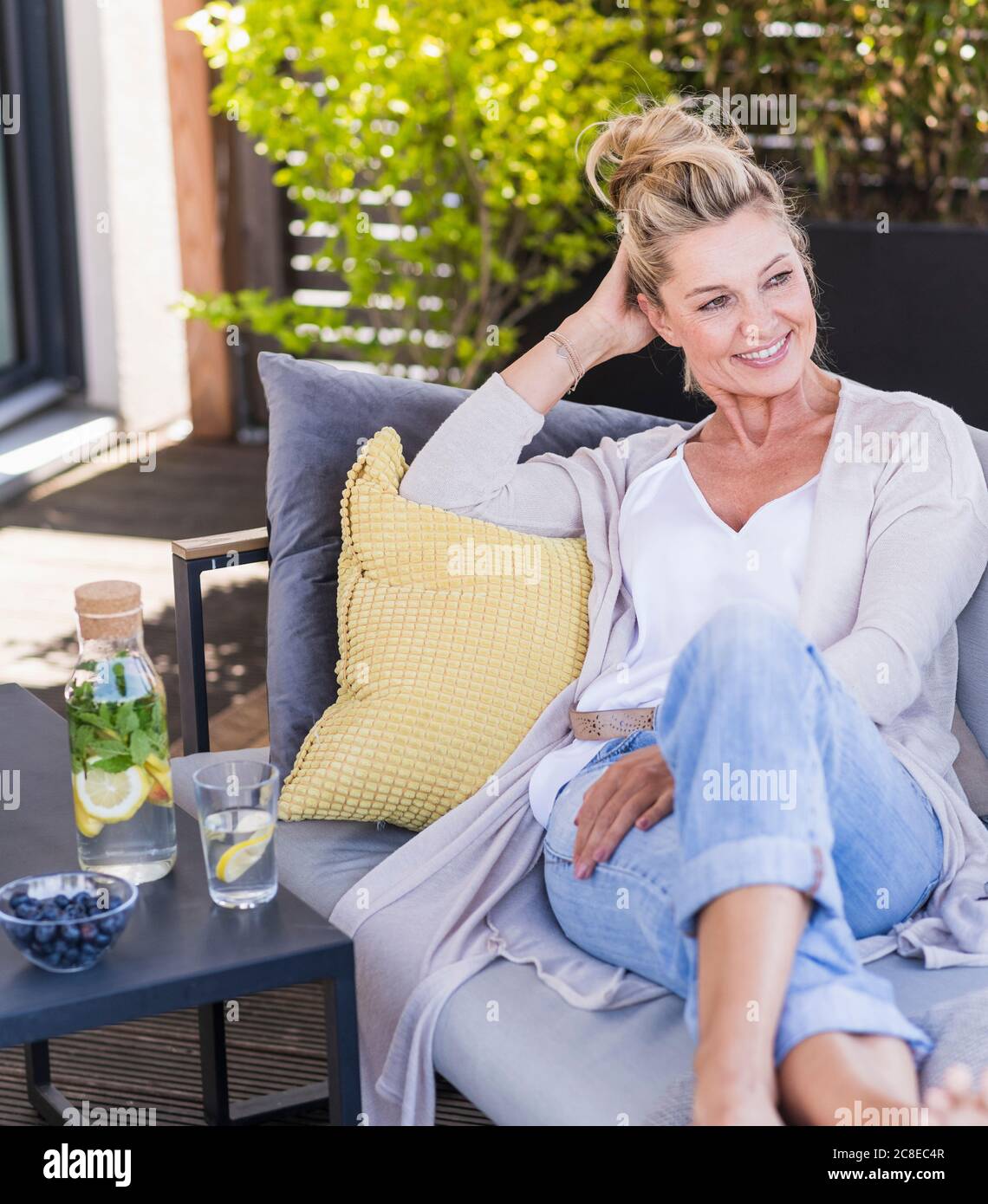 Portrait of smiling mature woman relaxing on terrace Stock Photo - Alamy