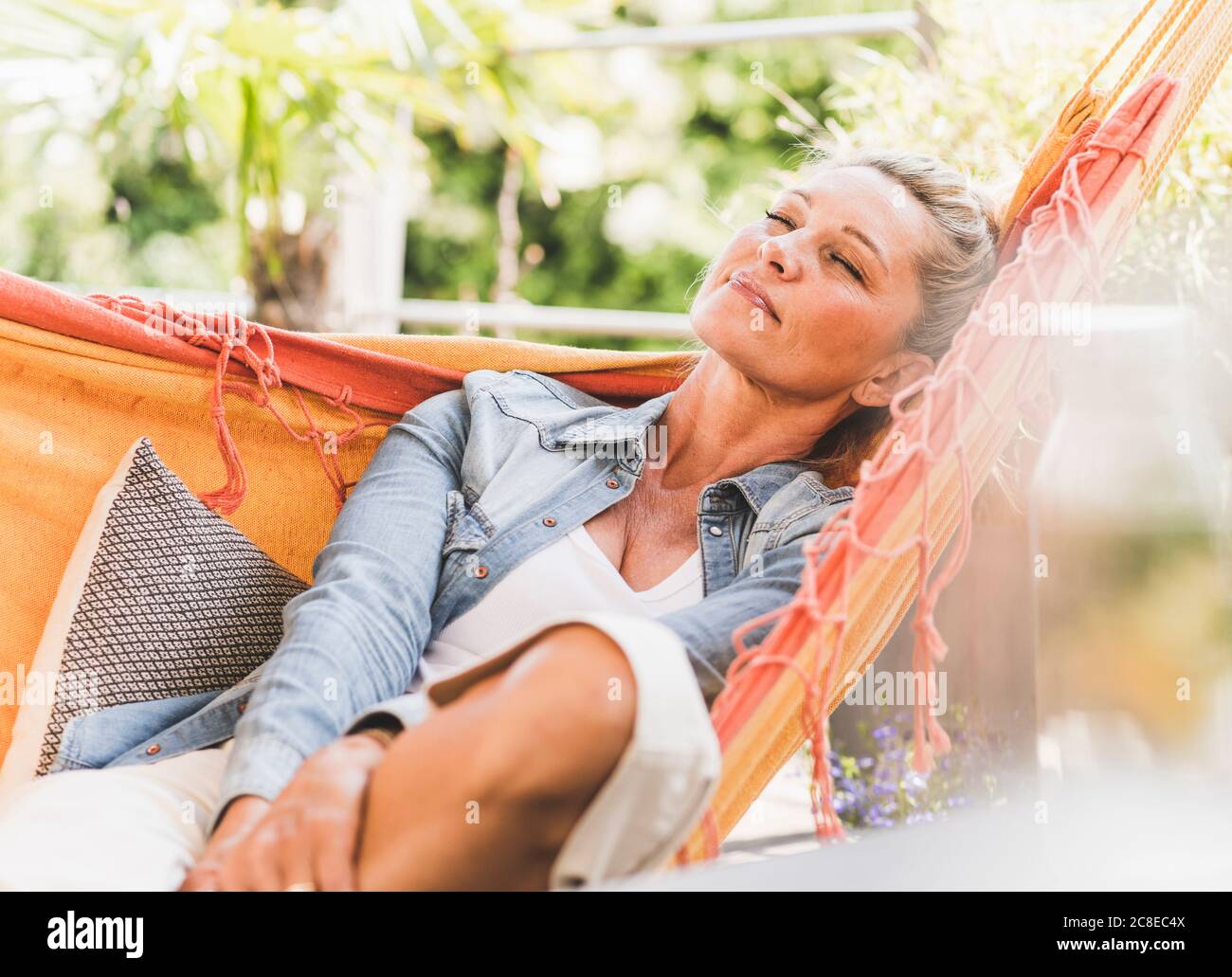 Portrait of mature woman with eyes closed relaxing in hammock on Stock ...