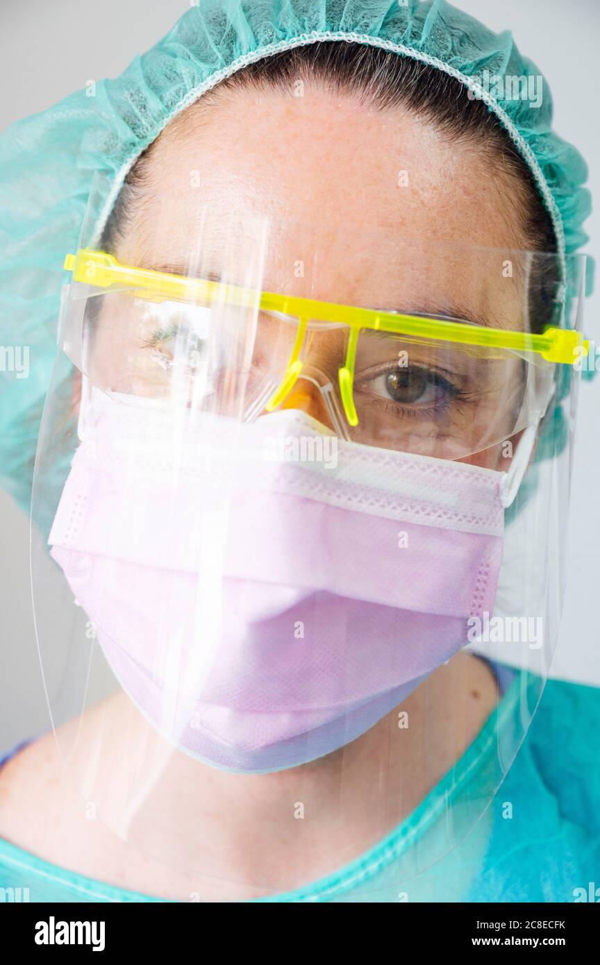 Closeup of female dentist wearing mask and eyewear in clinic Stock