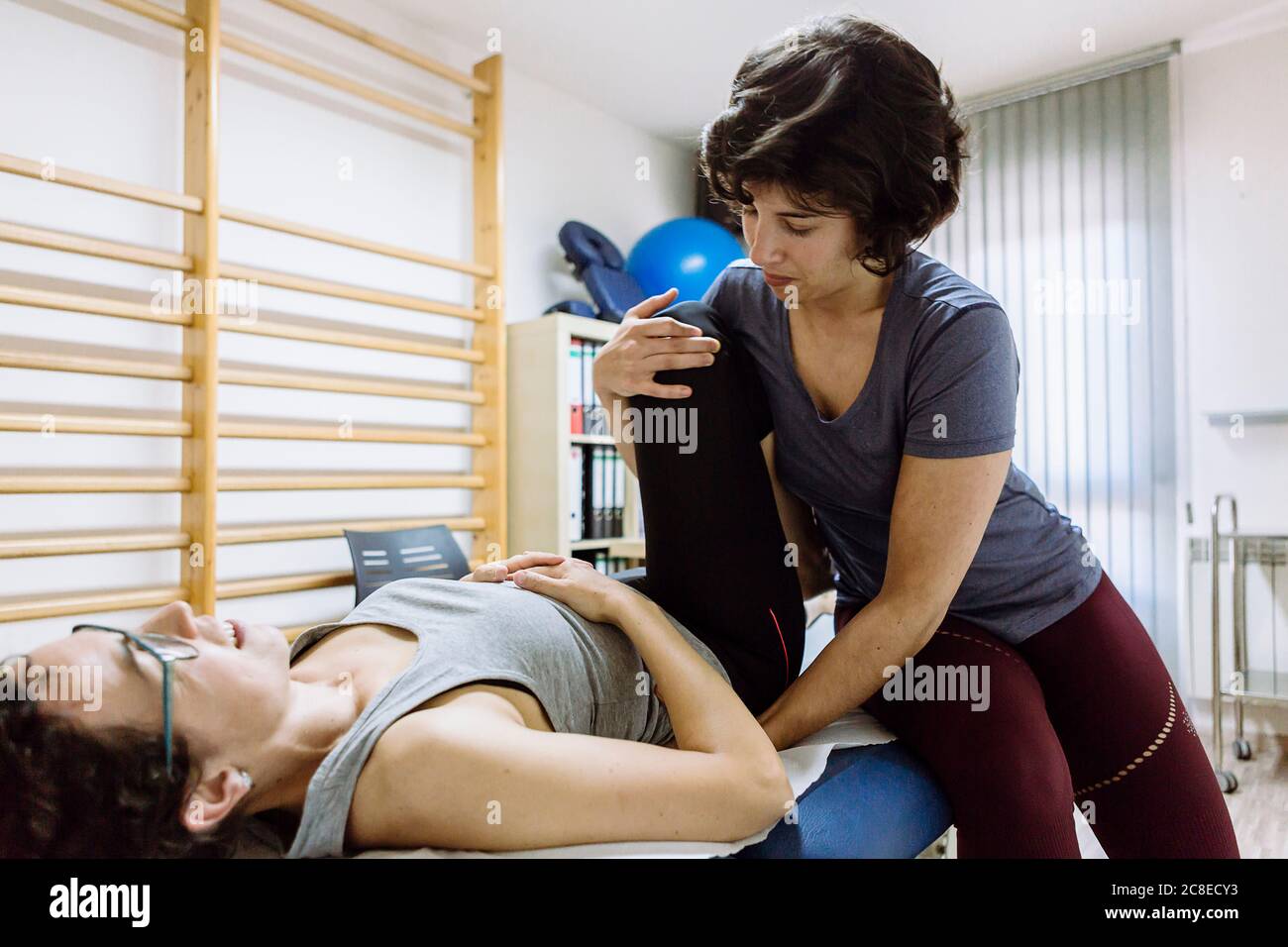 Female physiotherapist stretching leg of client Stock Photo