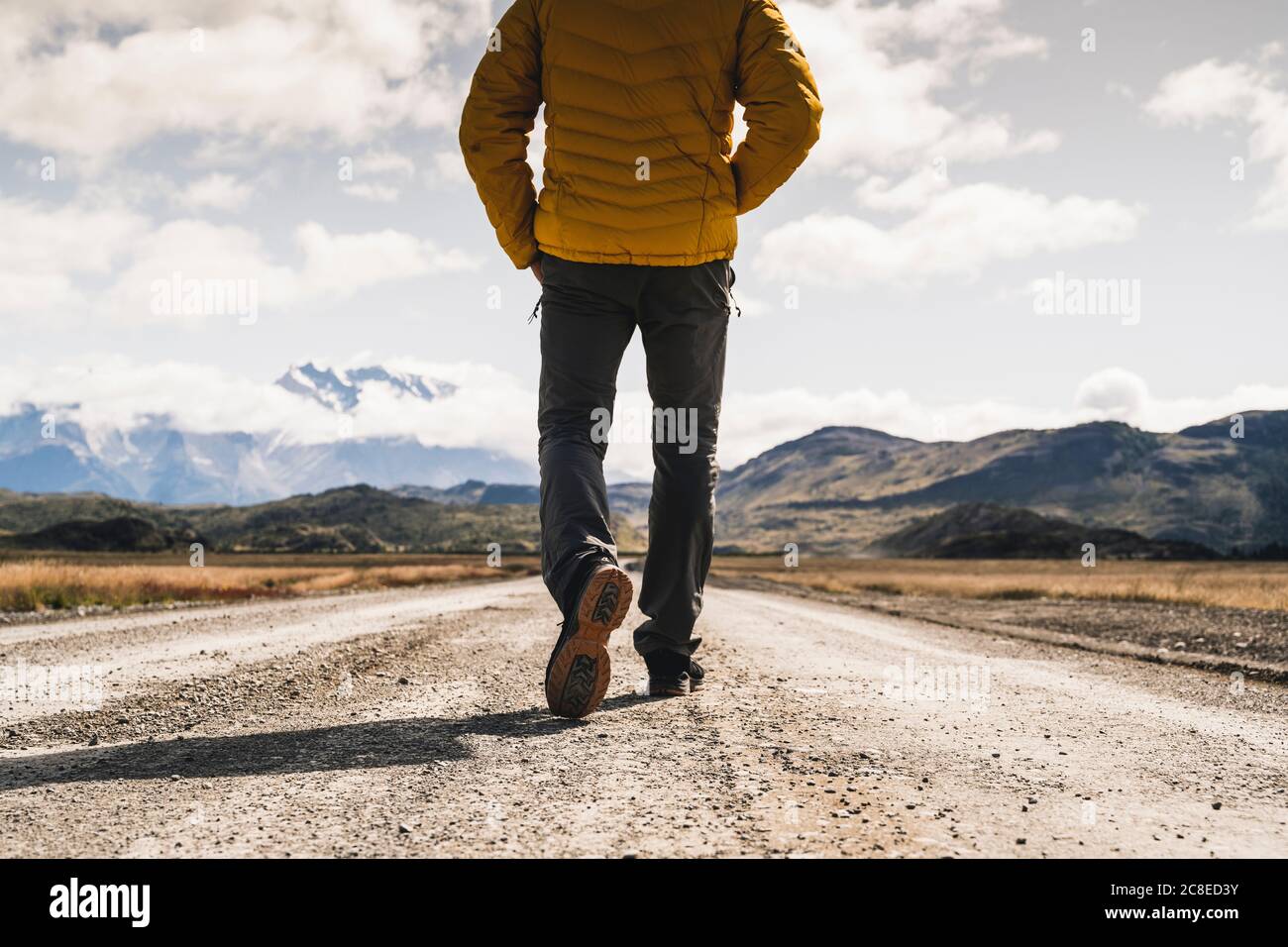 Low section of mature man walking on dirt road at Torres Del Paine National Park, Patagonia, Chile Stock Photo