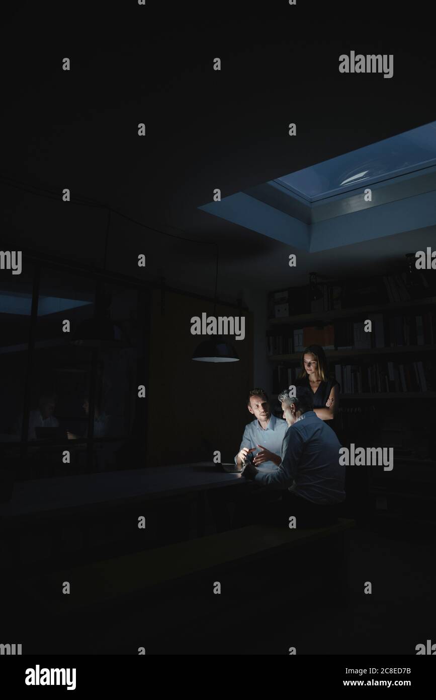 Team of business people working late in office, disussing solutions Stock Photo