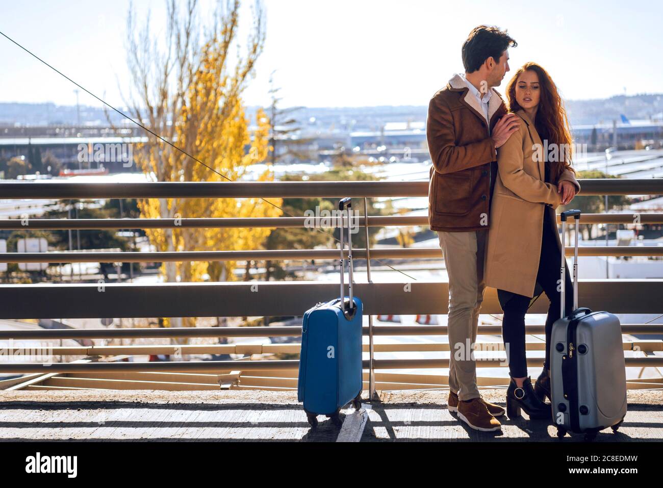 Romantic business couple standing on elevated walkway at airport Stock Photo