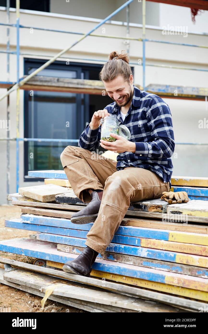 Happy worker having lunch break on a construction site Stock Photo