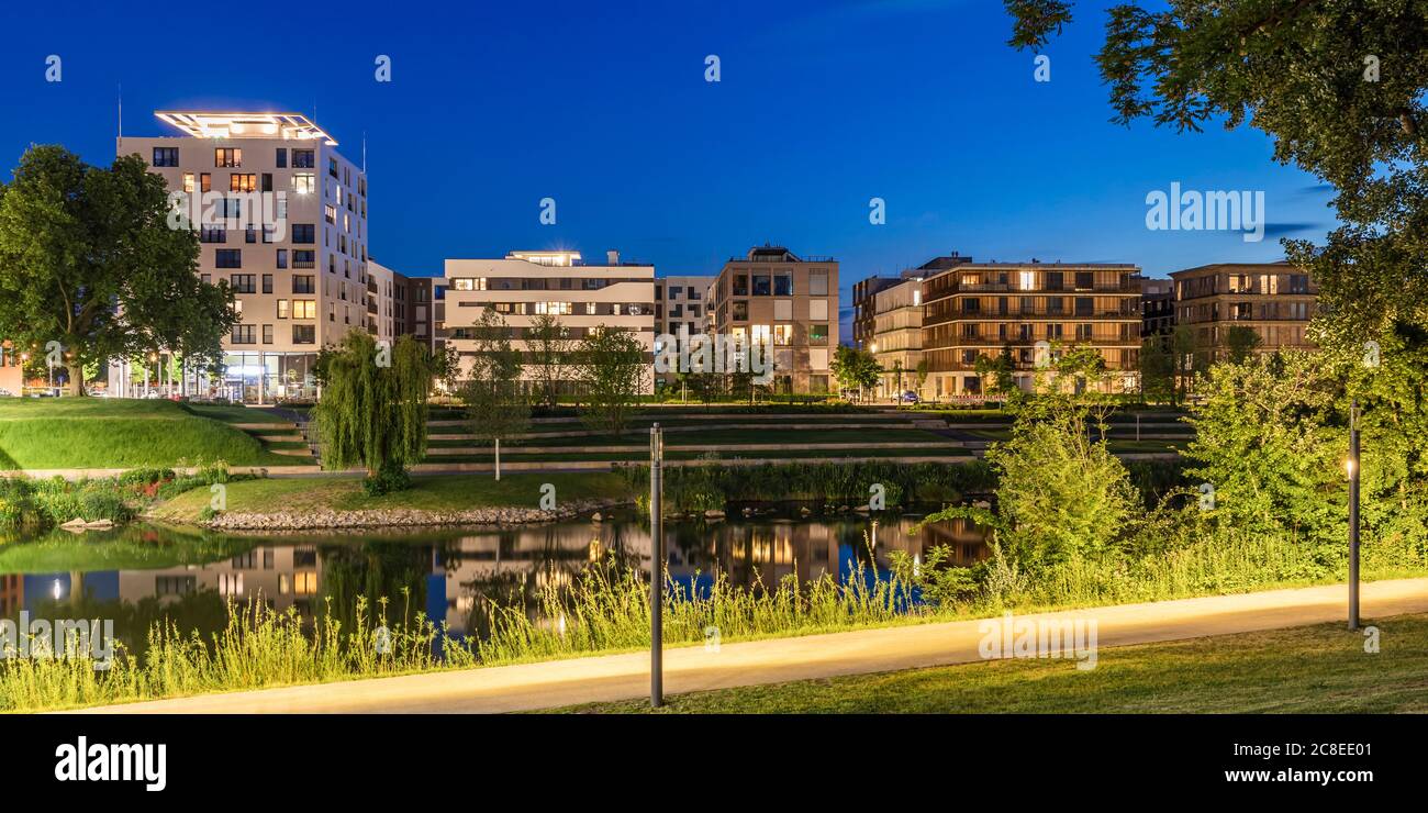 Germany, Baden-Wrttemberg, Heilbronn, Neckar, district of Neckarbogen, New energy efficient apartment buildings illuminated at night Stock Photo