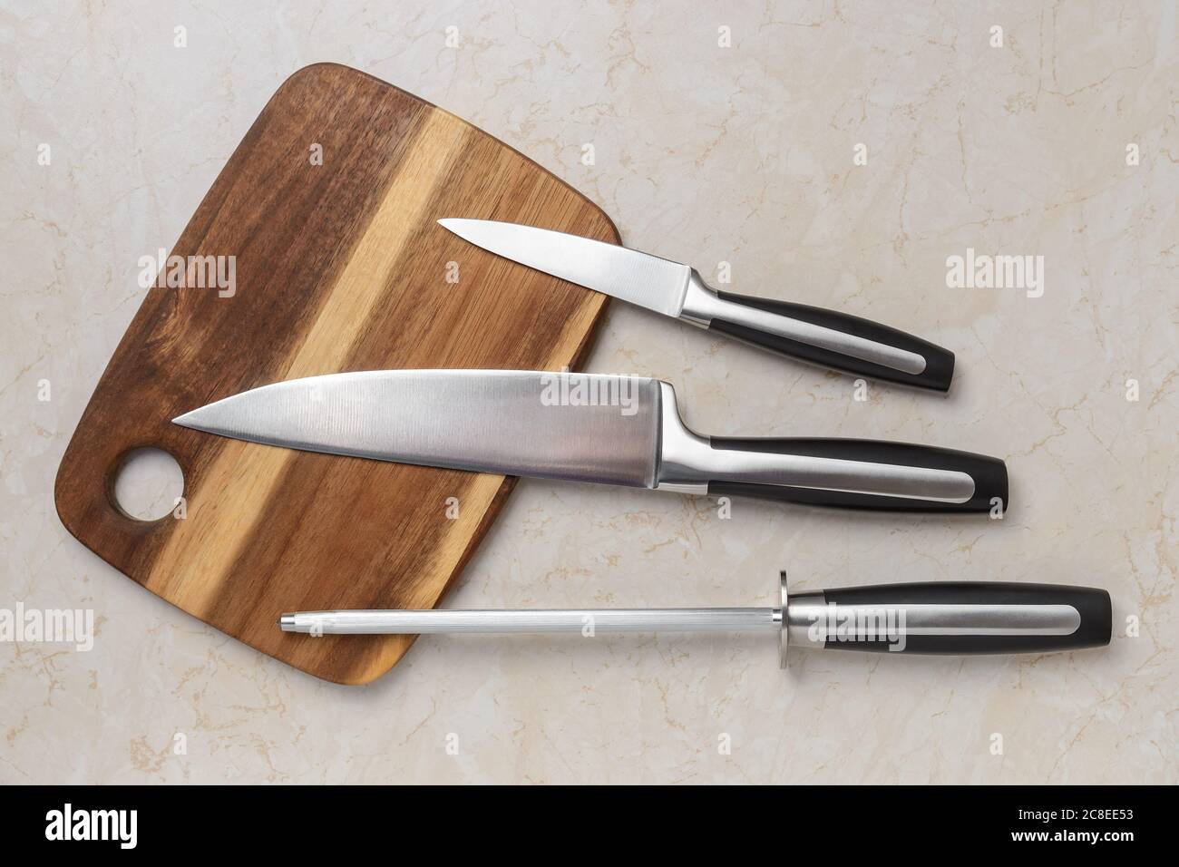 Professional chef knife, peeling knife and sharpening steel on wood cutting  board over a kitchen table. Chef working tools. Modern kitchen utensils  Stock Photo - Alamy