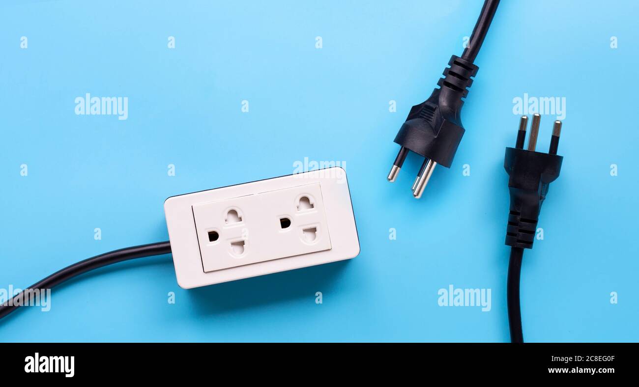 Electrical power strip and plug on blue background. Top view Stock Photo