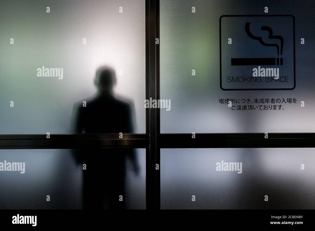 A smoker in a smoking area of a building in Roppongi, Tokyo, Japan