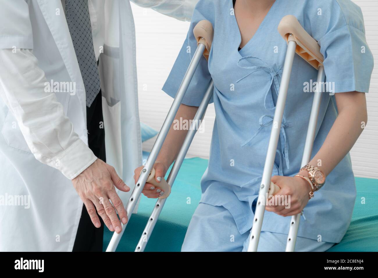 Doctor takes care of patient in crutch at hospital Stock Photo Alamy