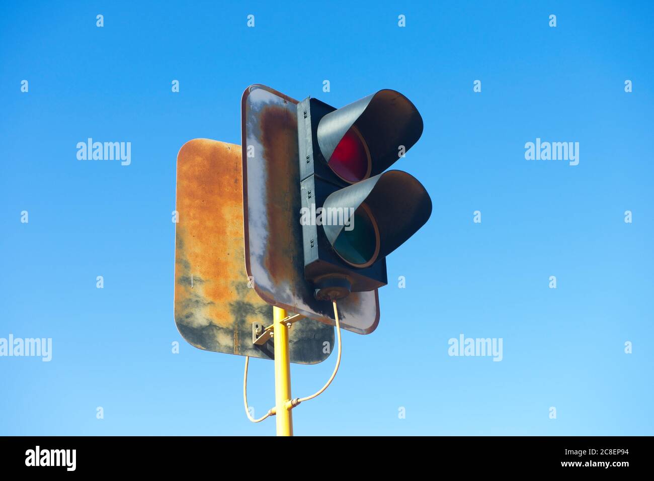 Rusty Trafic Light Out of service rusty traffic light on yellow pole with sunny blue sky ...
