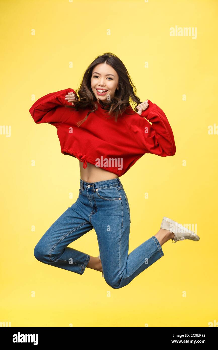 Full length portrait of a smiling pretty woman jumping isolated on a ...