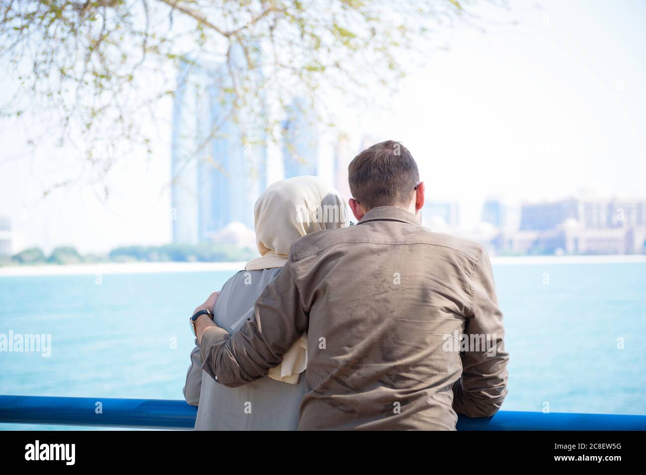 Arabic couple hugs by the ocean and looks out Stock Photo Alamy