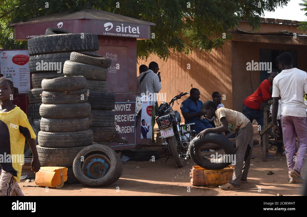 A child laborer at a tire repair shop in Niger, Africa, looking for the leak in an inner tube Stock Photo