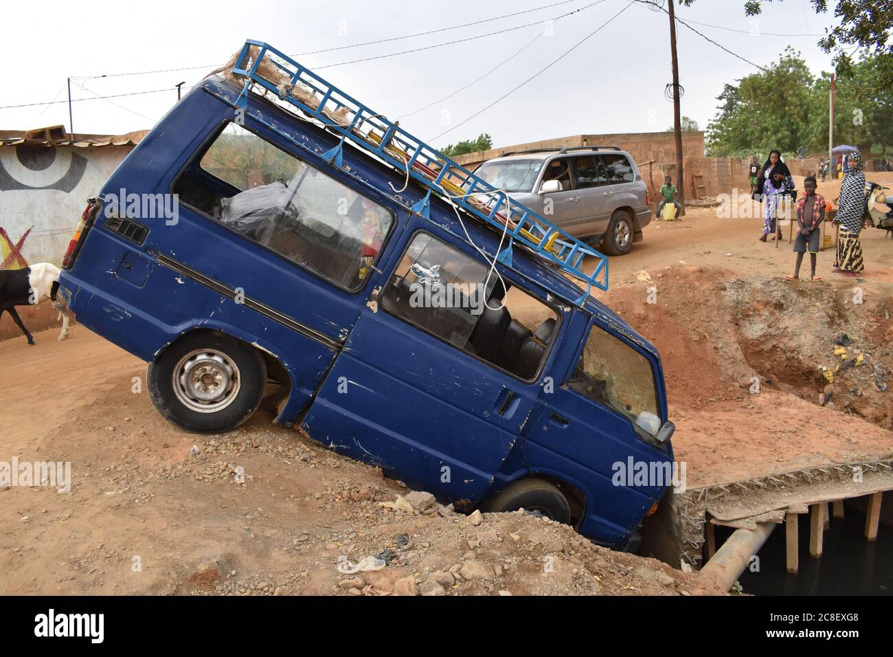 An upended taxi van that drove into a roadside washout in Niamey, Niger. Happily, no one was hurt! Stock Photo