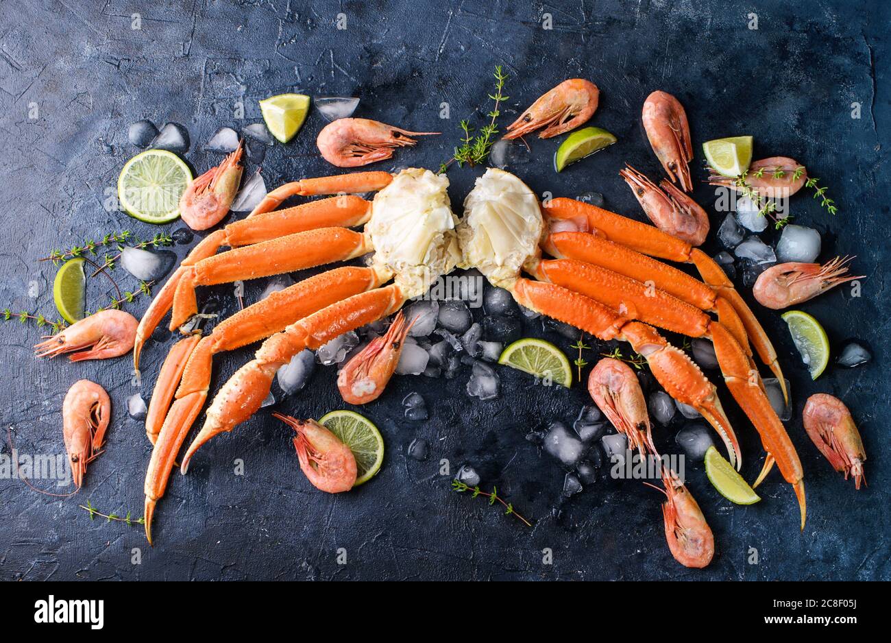 Fresh crab claws, lime, spices, spices, ice, shrimp, vegetables on a