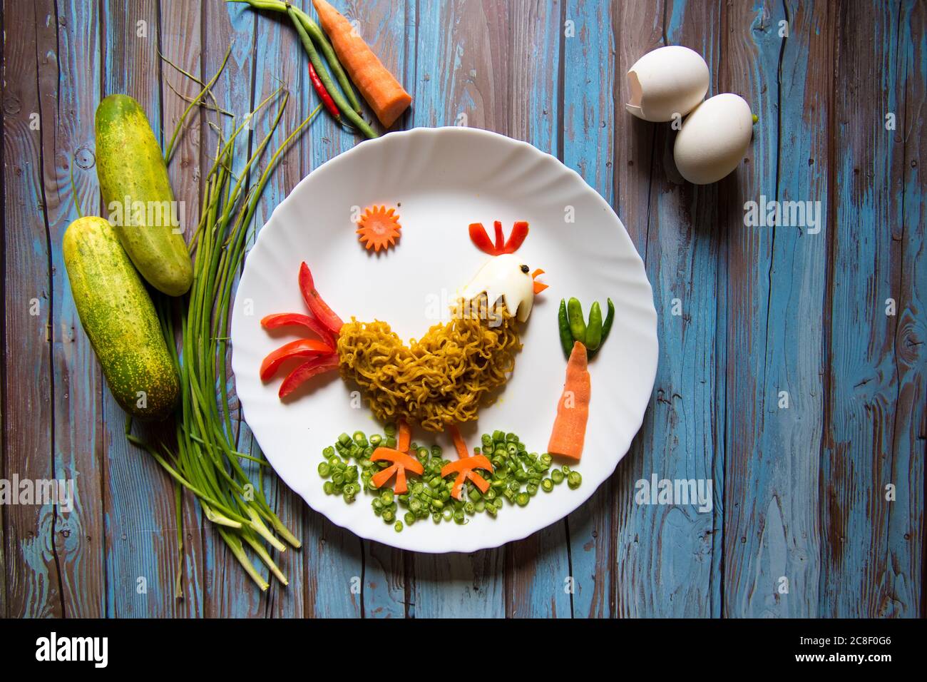 Rooster in food art in a plate on a background Stock Photo