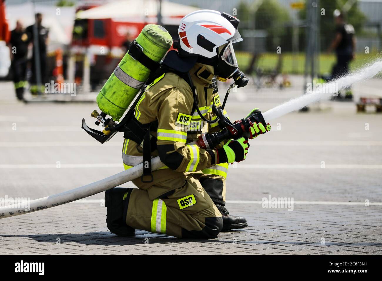 a firefighter in heavy equipment seen while putting out the fire.  The Volunteer Fire Brigade on the premises of the Man Trucks factory performs exerc Stock Photo