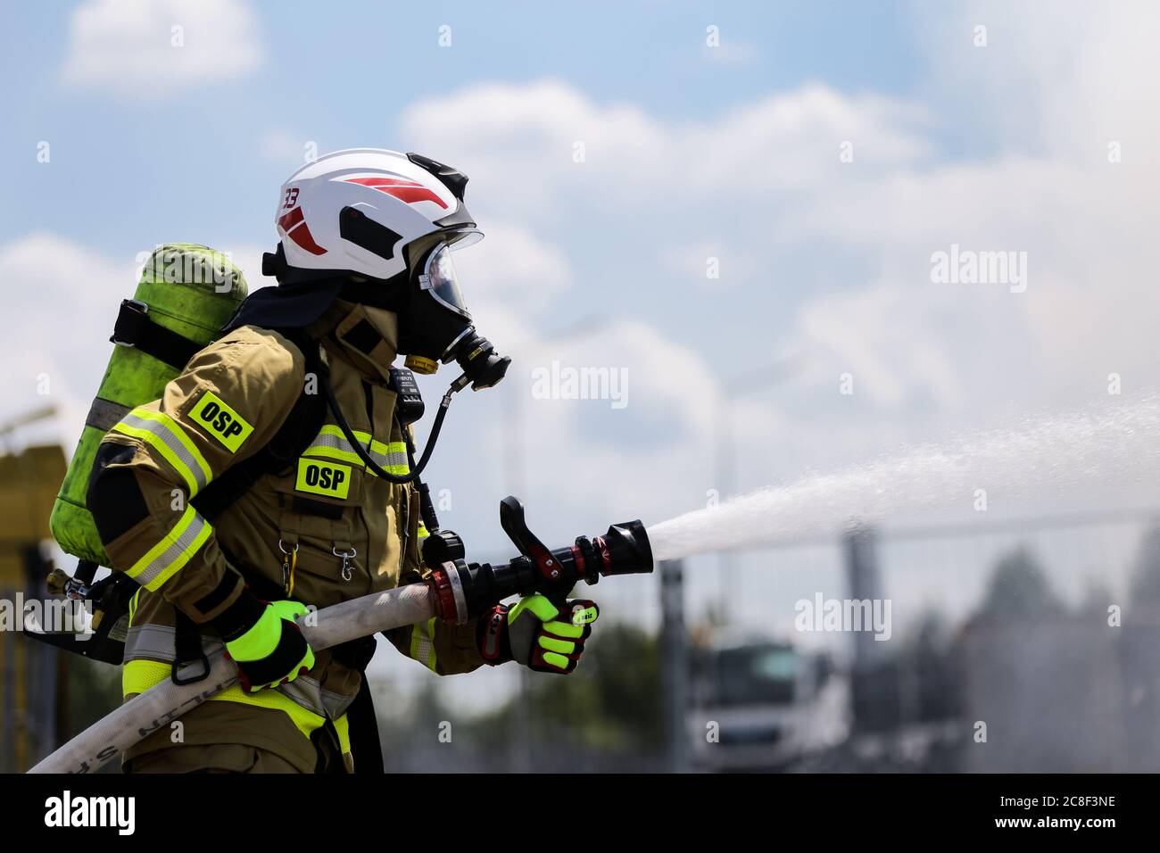 a firefighter in heavy equipment seen while putting out the fire.  The Volunteer Fire Brigade on the premises of the Man Trucks factory performs exerc Stock Photo