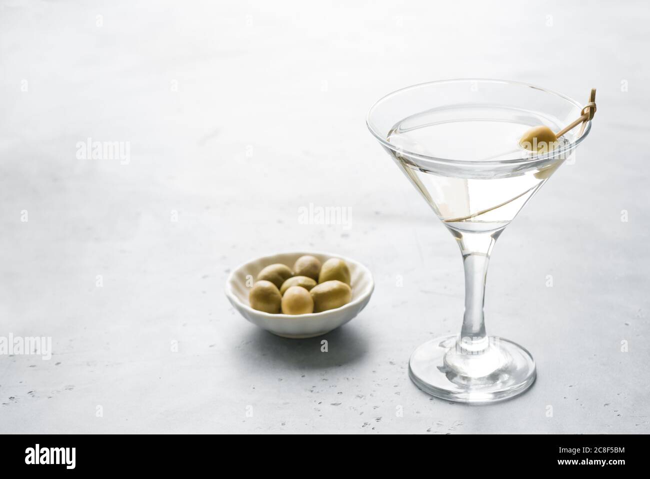 Classic Dry Martini with olives on light background, copy space