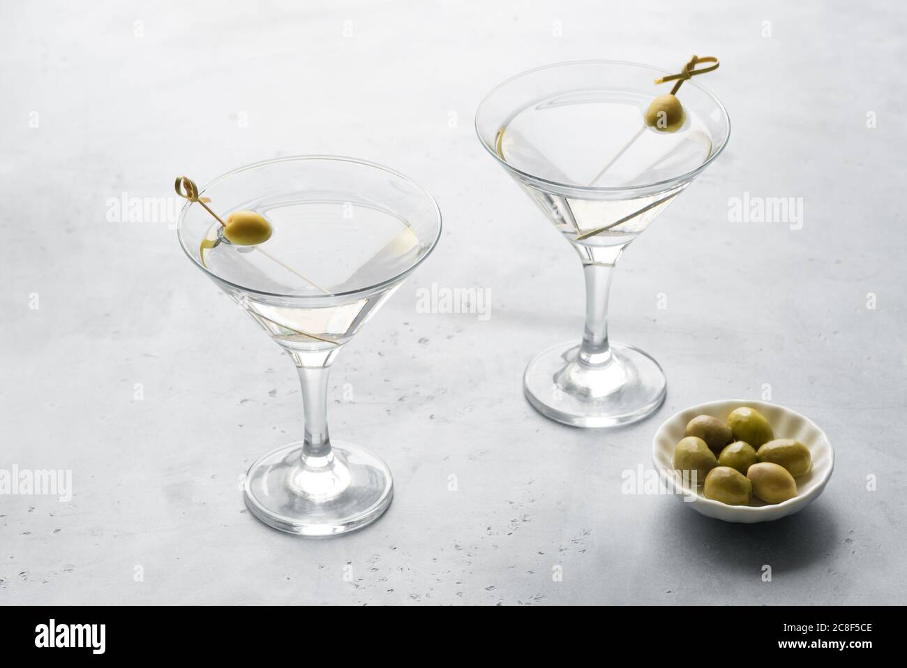 Classic Dry Martini with olives on light background, copy space