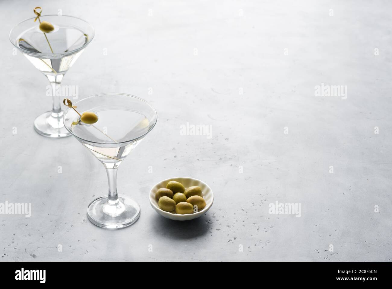 Classic Dry Martini with olives on light background, copy space