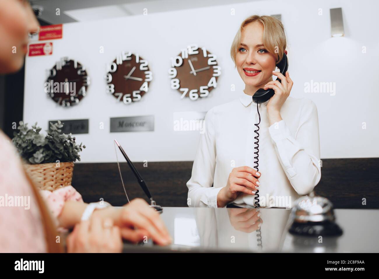 Female receptionist in hotel talking on the phone at work Stock Photo