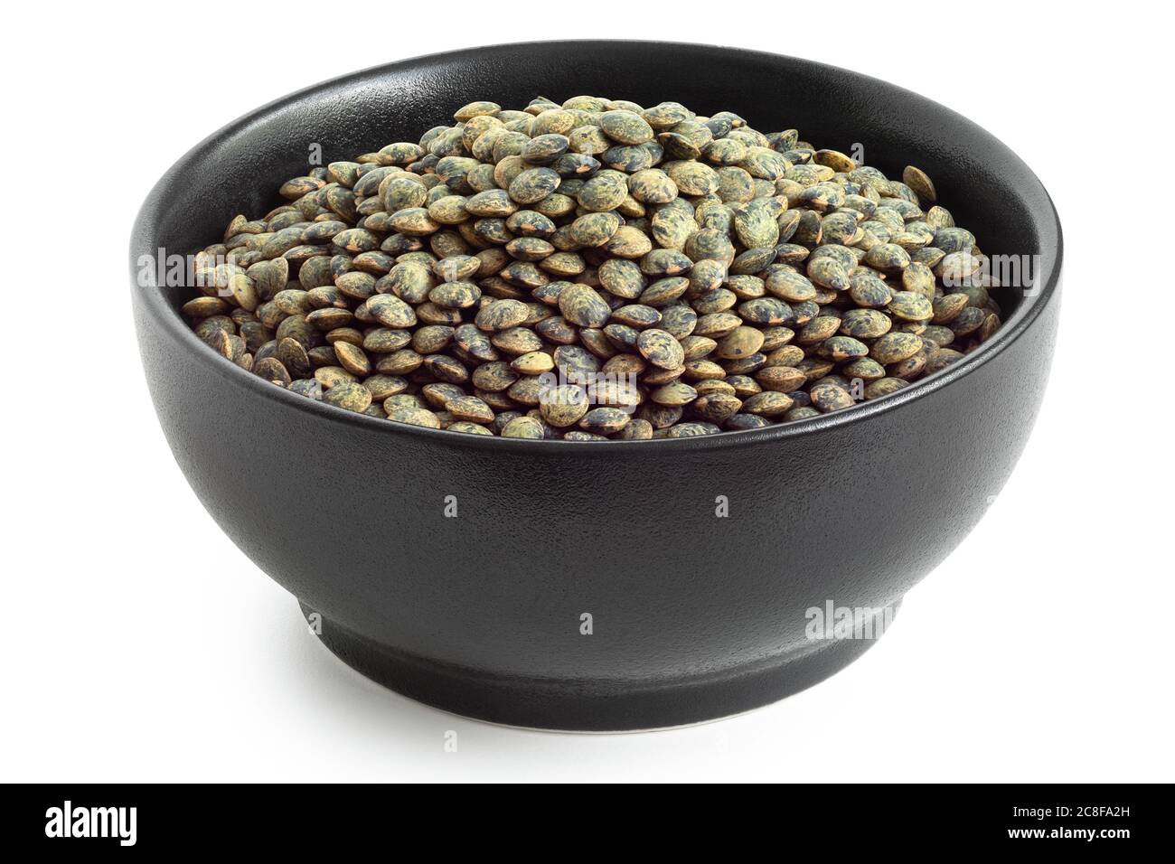 Dry french green puy lentils in black ceramic bowl isolated on white. High angle. Stock Photo
