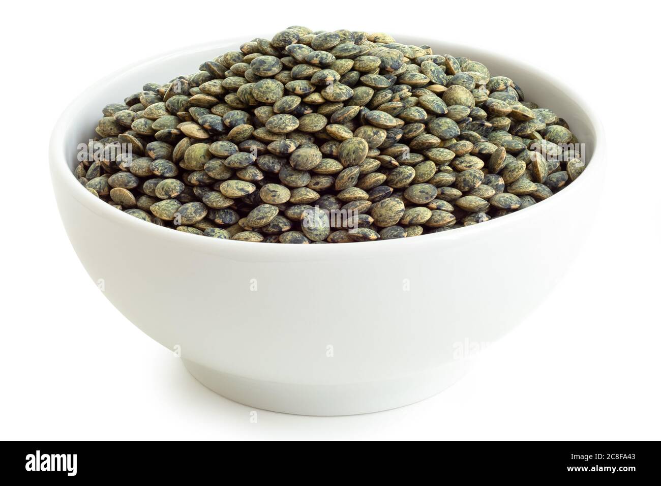 Dry french green puy lentils in white ceramic bowl isolated on white. High angle. Stock Photo