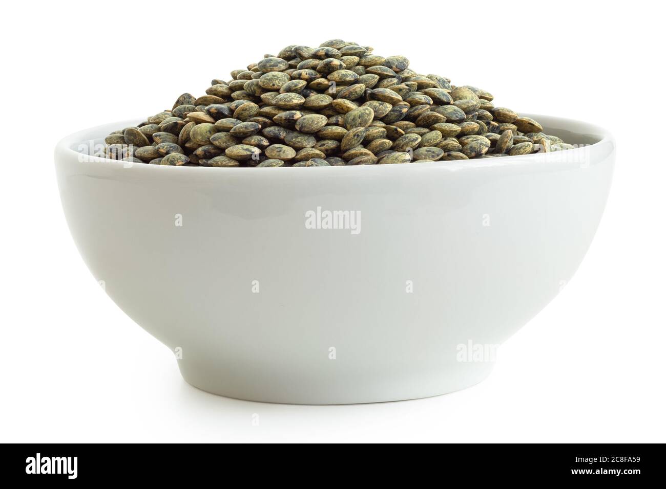 Dry french green puy lentils in white ceramic bowl isolated on white. Low angle. Stock Photo