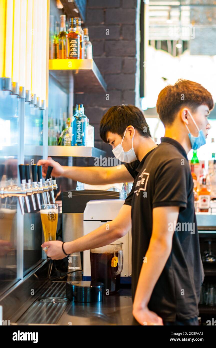 A barman pouring a beer at Shanghai Brewhouse in Jing’an District. Stock Photo