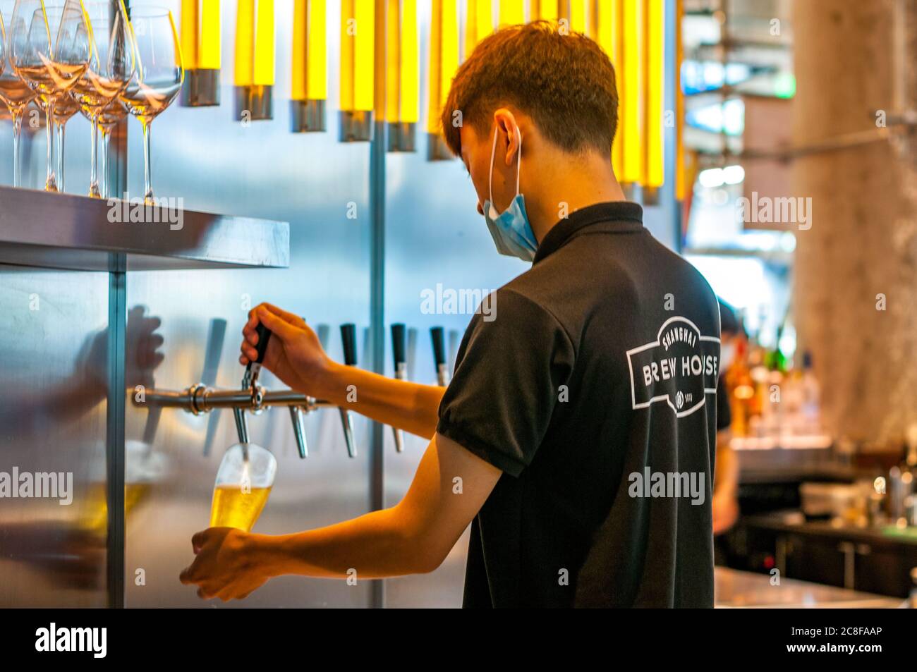 A barman pouring a cider at Shanghai Brewhouse in Jing’an District. Stock Photo