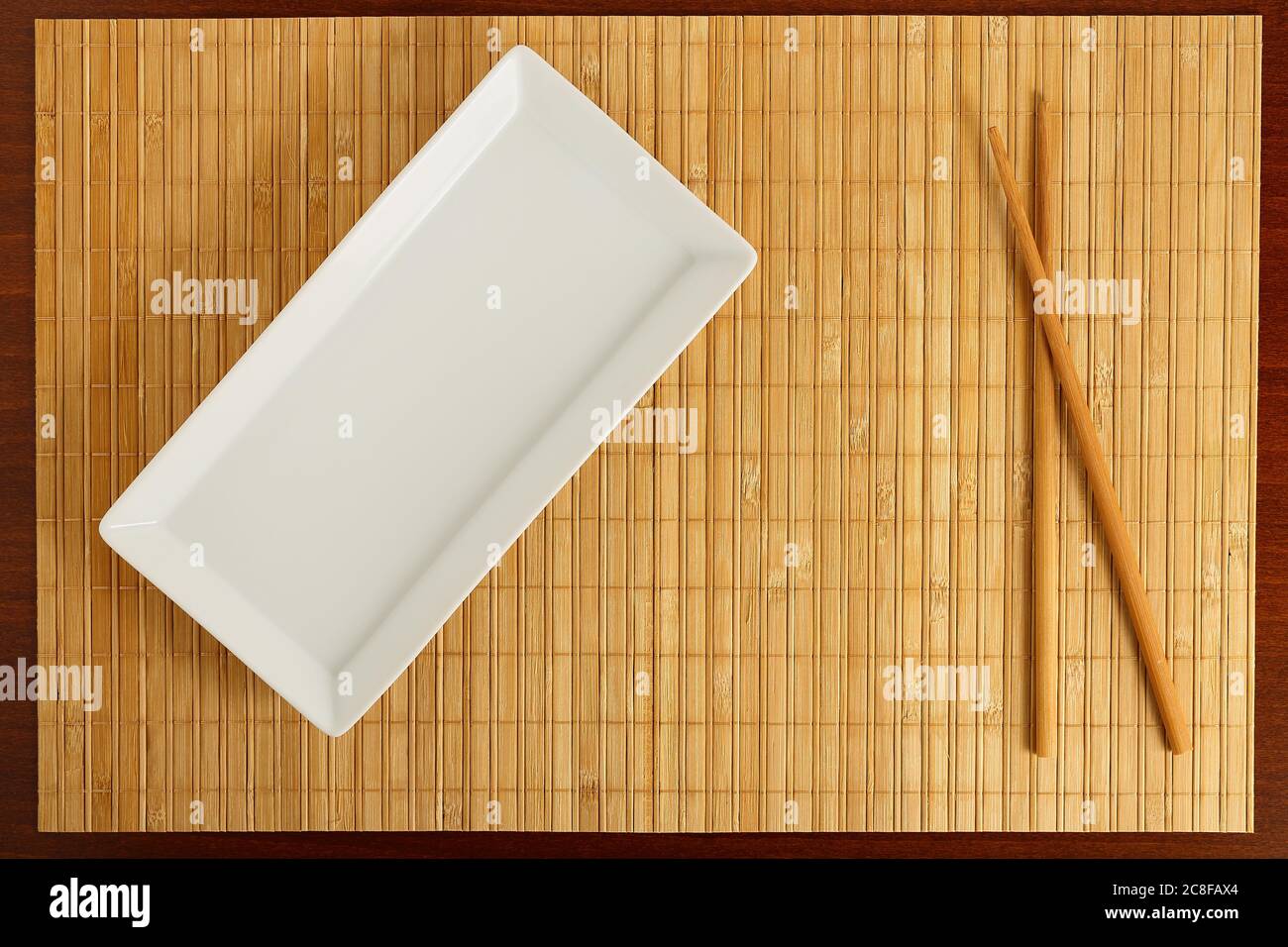 empty rectangular dish with chopsticks on bamboo surface Stock Photo
