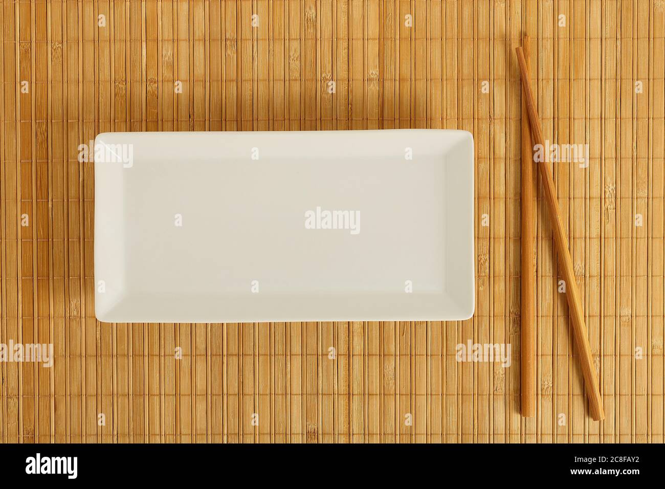 empty rectangular dish with chopsticks on bamboo surface Stock Photo