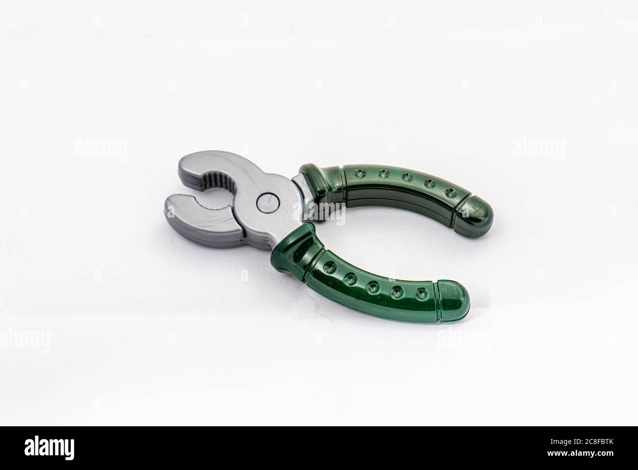 Silver and green plastic toy pliers too on white background Stock Photo ...