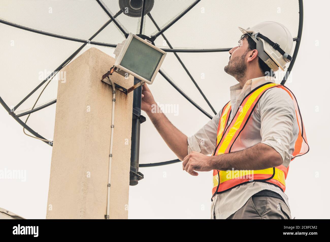 Technician or engineer working with satellite dish Stock Photo Alamy
