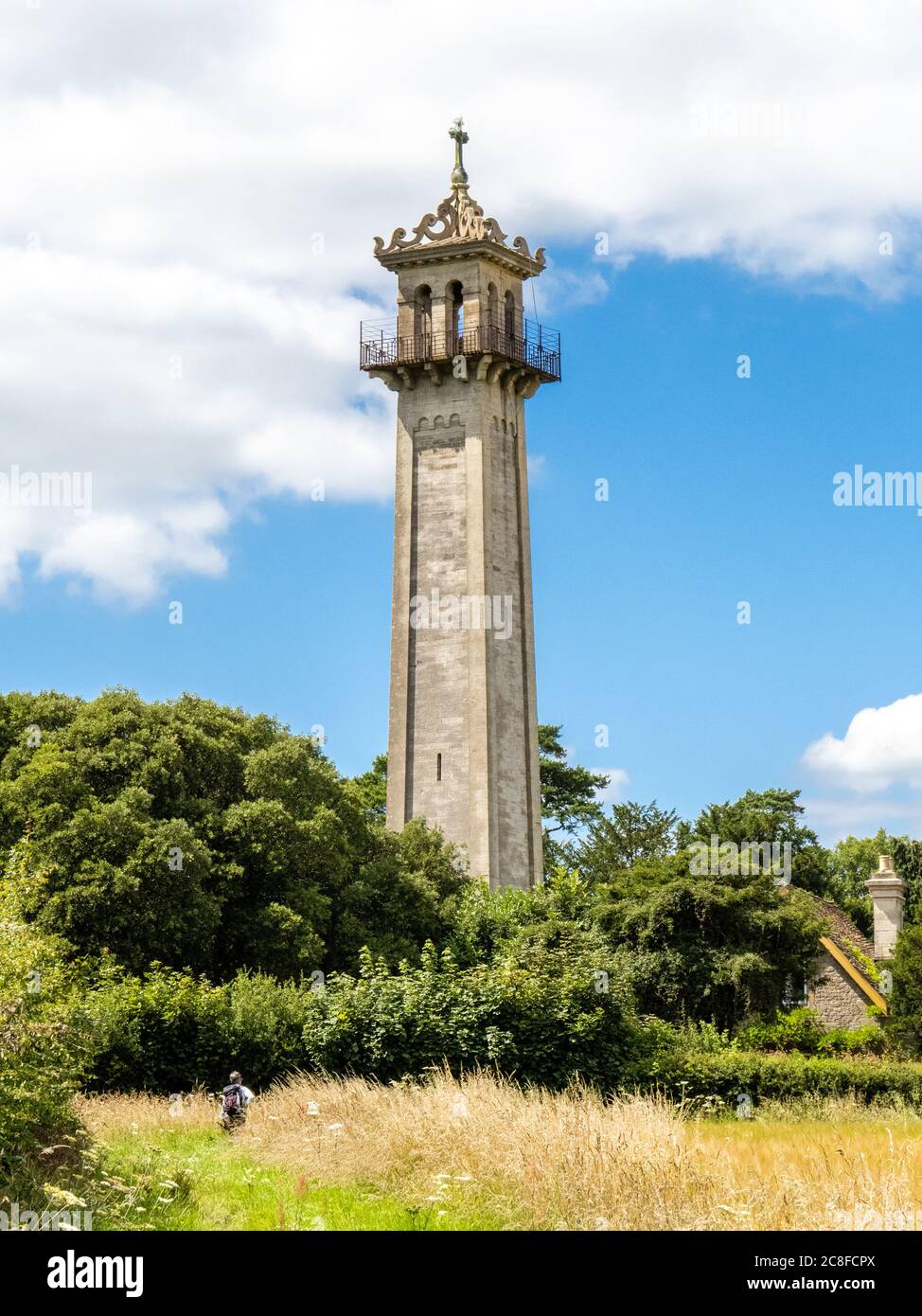 A walker approaching the Somerset Monument near Hawkesbury Upton in Wiltshire built in 1834 to commemorate Lord Robert Somerset soldier and MP Stock Photo