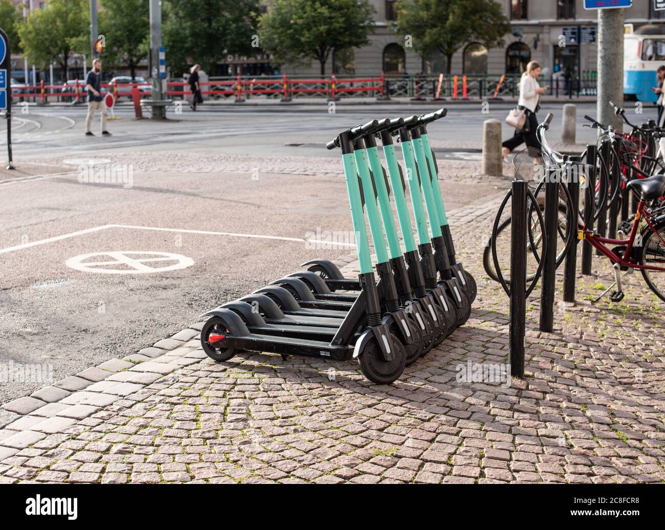 Seven electric scooters parked in a row. Stock Photo