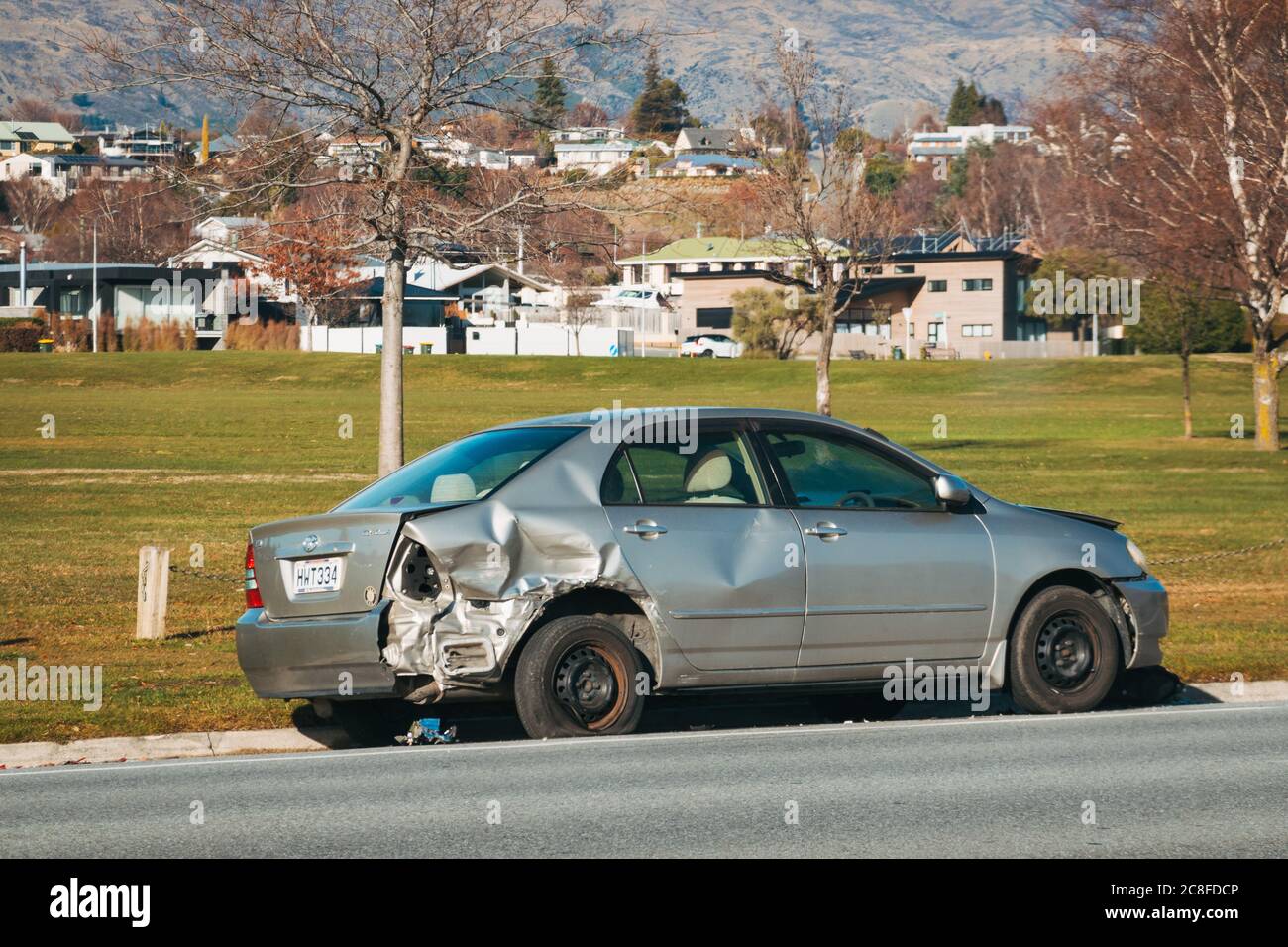 A wrecked car parked on the side of the road in Wanaka township, New Zealand, after it crashed and rolled over Stock Photo
