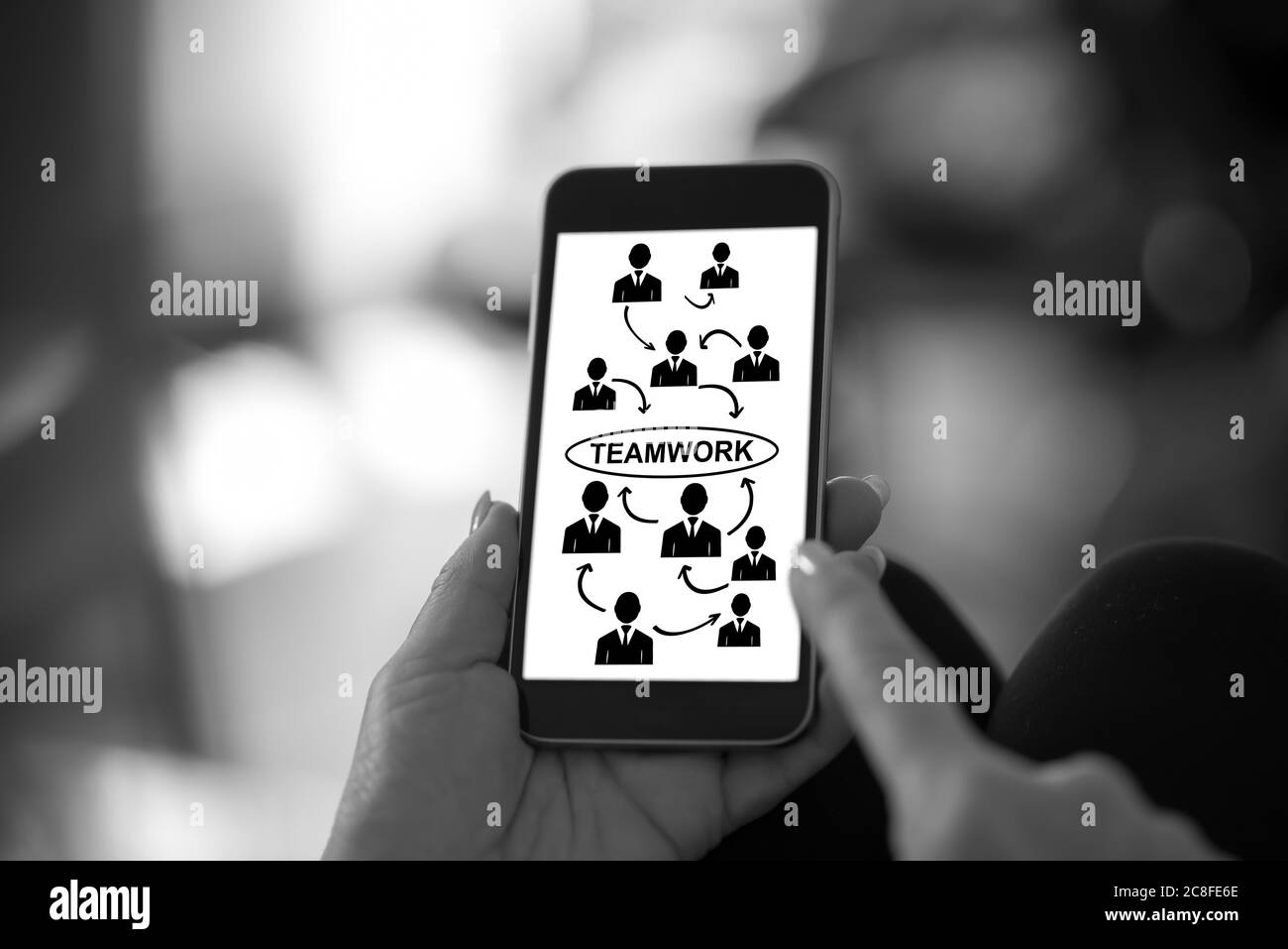 Hand holding a smartphone with teamwork concept Stock Photo - Alamy