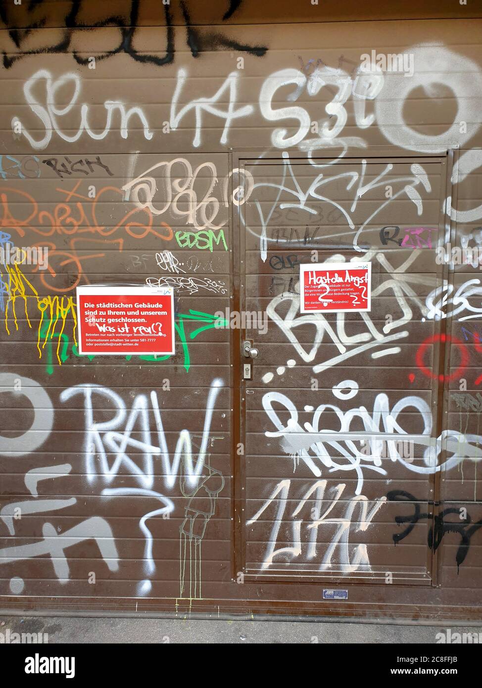 information sign for obligation to wear a mask with daub Hast du Angst? Was ist real? Are you afraid? What is real?, Germany Stock Photo