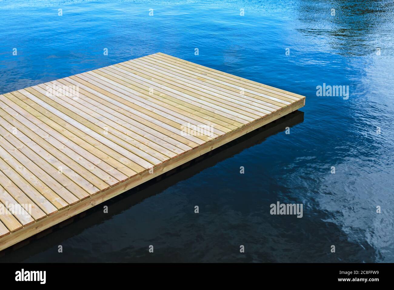 Newly built wooden landing stage on deep blue water Stock Photo