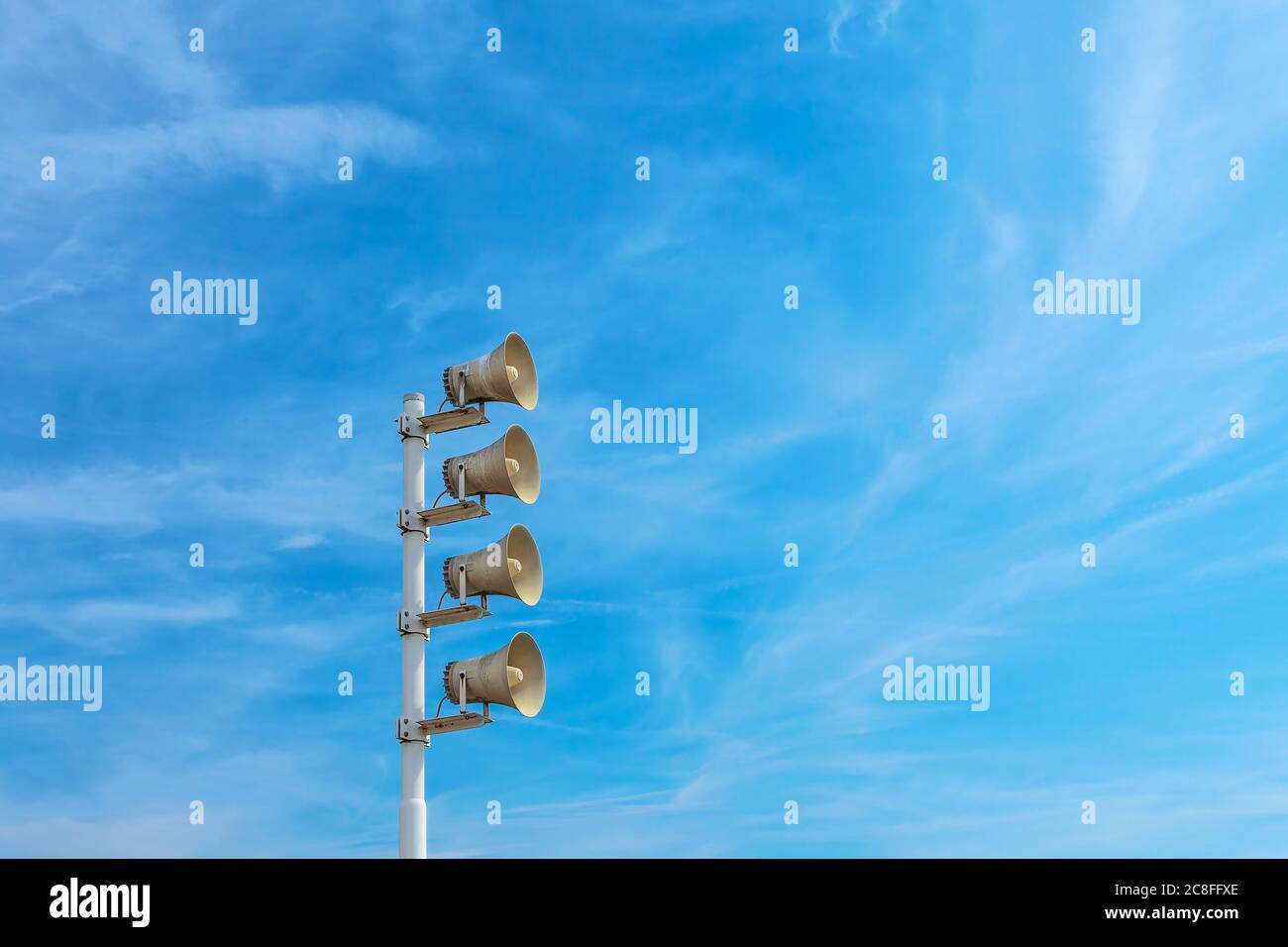 Row of outdoor megaphones against a blue sky Stock Photo