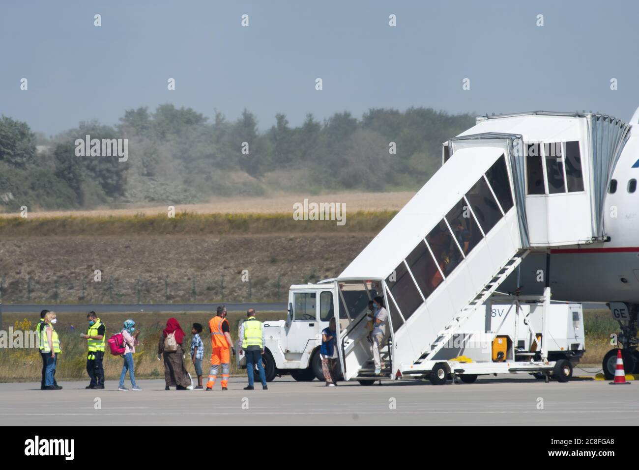 Calden, Germany. 24th July, 2020. Refugees from Greek refugee camps get off  the plane at Kassel-Calden (Kassel Airport). The German government has  brought a group of sick children with their relatives from